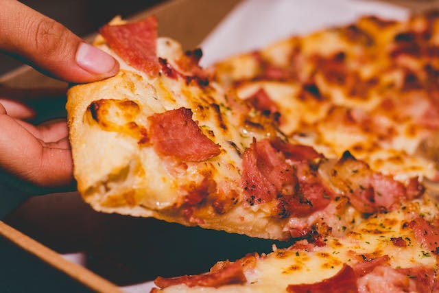A man eating pizza at a bar